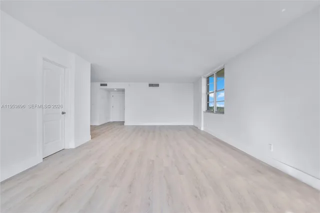 a view of a room with wooden floor and window