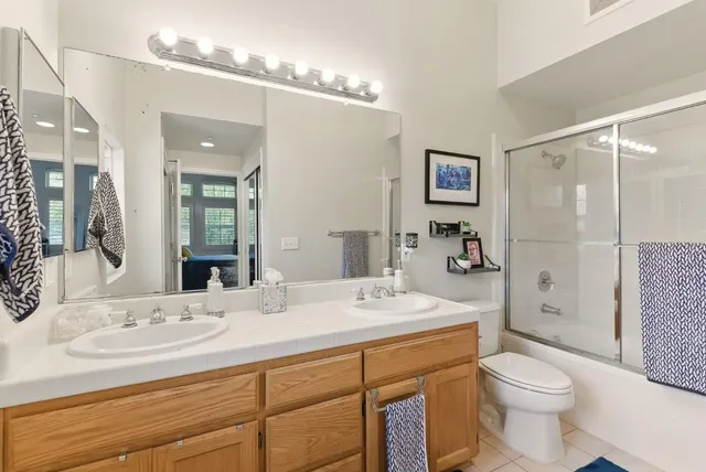 a bathroom with a sink a toilet and a mirror