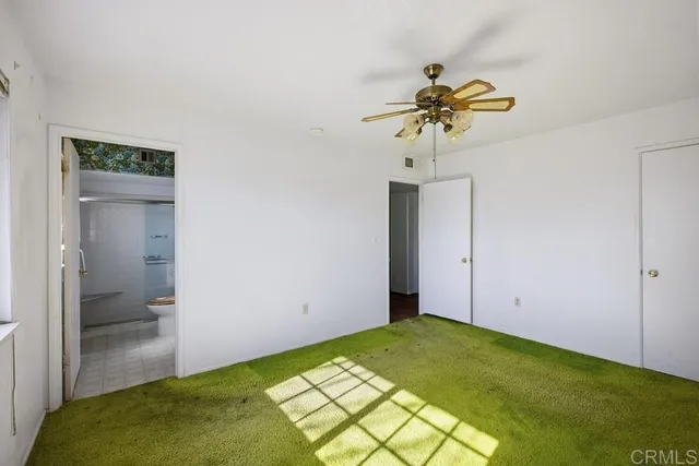a view of a room with a chandelier fan and bathroom