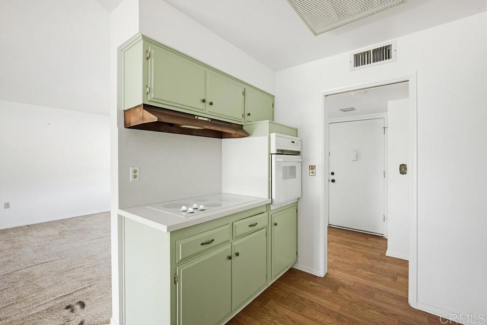 27077 El Rancho Road Menifee, CA 92586 - Photo 8 of 31 a kitchen with white cabinets and wooden floor