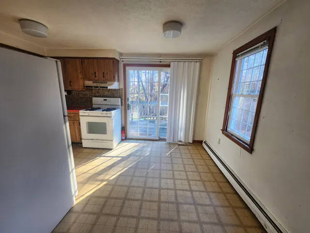 a view of empty room with a fireplace and windows