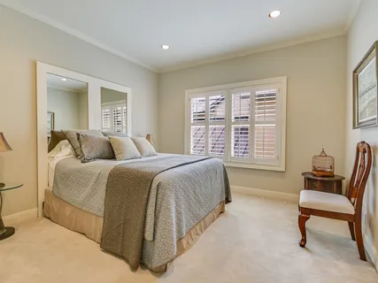 a spacious bedroom with a bed and a chair
