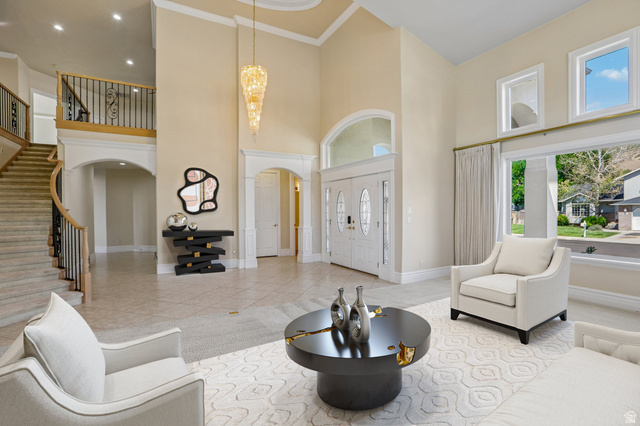 220 East Ridge Road Orem, UT 84057 - Photo 2 of 52 Two-story foyer with tile flooring, a grand curved staircase featuring wrought iron balusters, and double entry doors with decorative glass