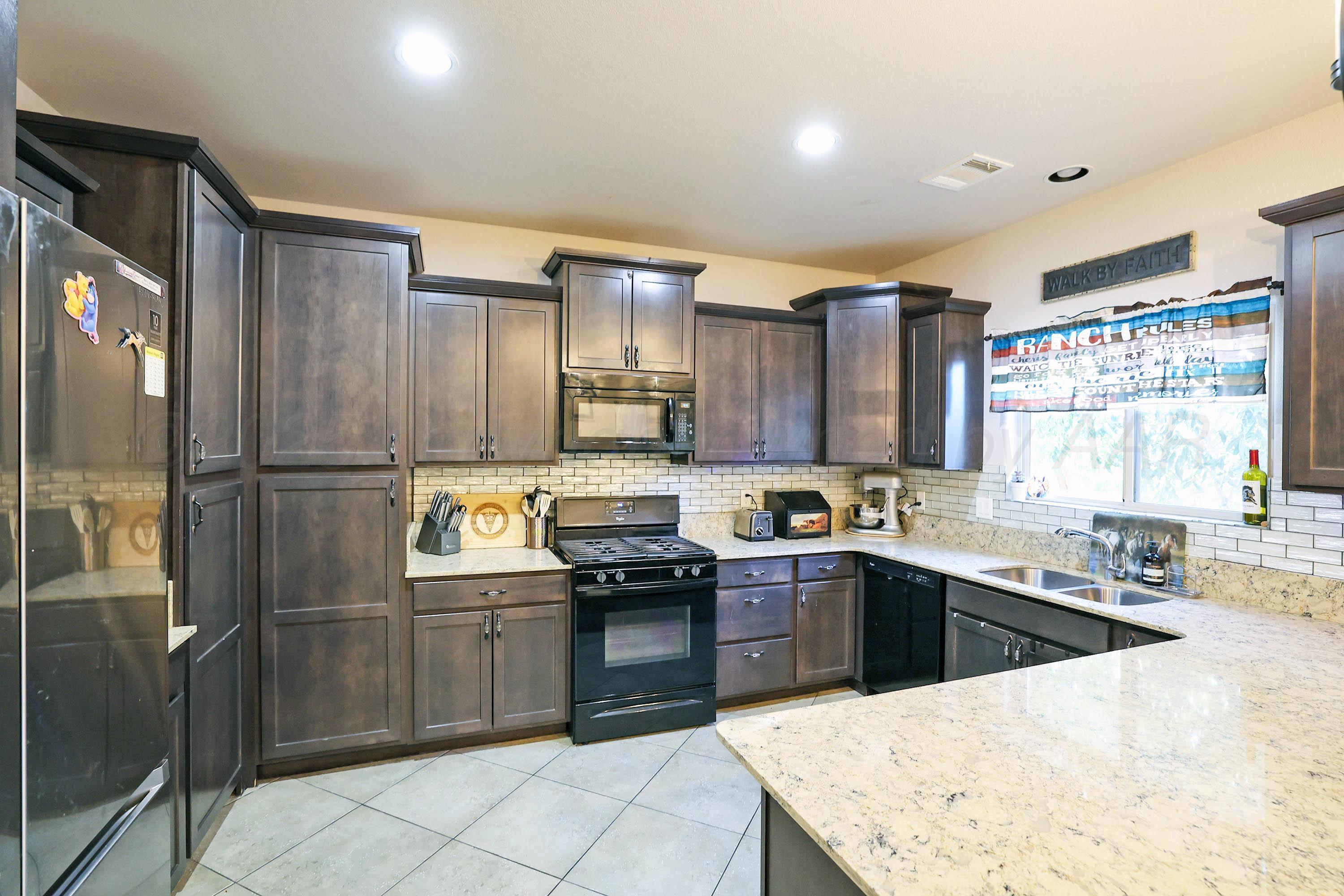 1003 Cabernet Way Amarillo, TX 79124 - Photo 14 of 36 a kitchen with stainless steel appliances granite countertop a sink stove and refrigerator
