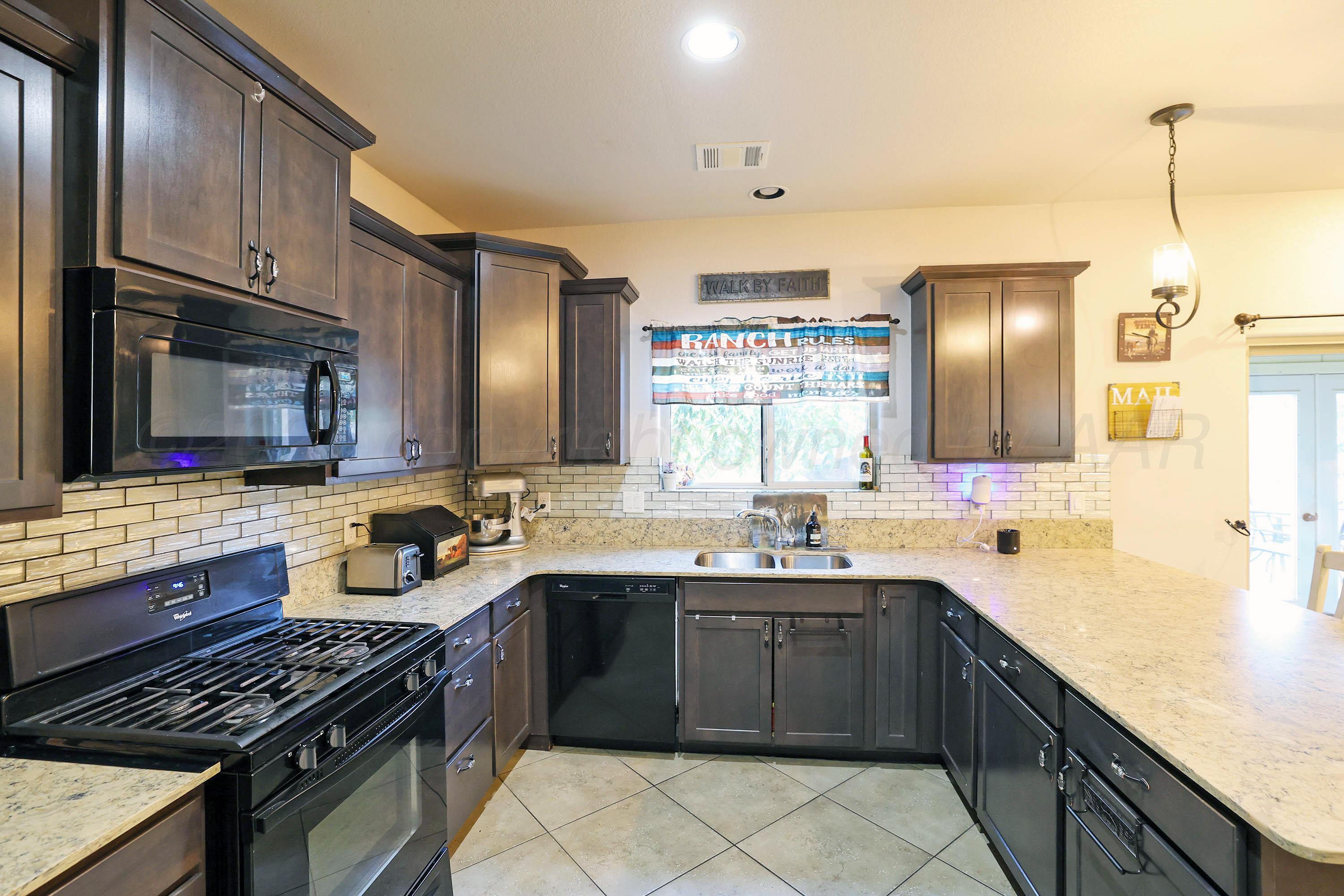 1003 Cabernet Way Amarillo, TX 79124 - Photo 15 of 36 a kitchen with a sink stove top oven and microwave