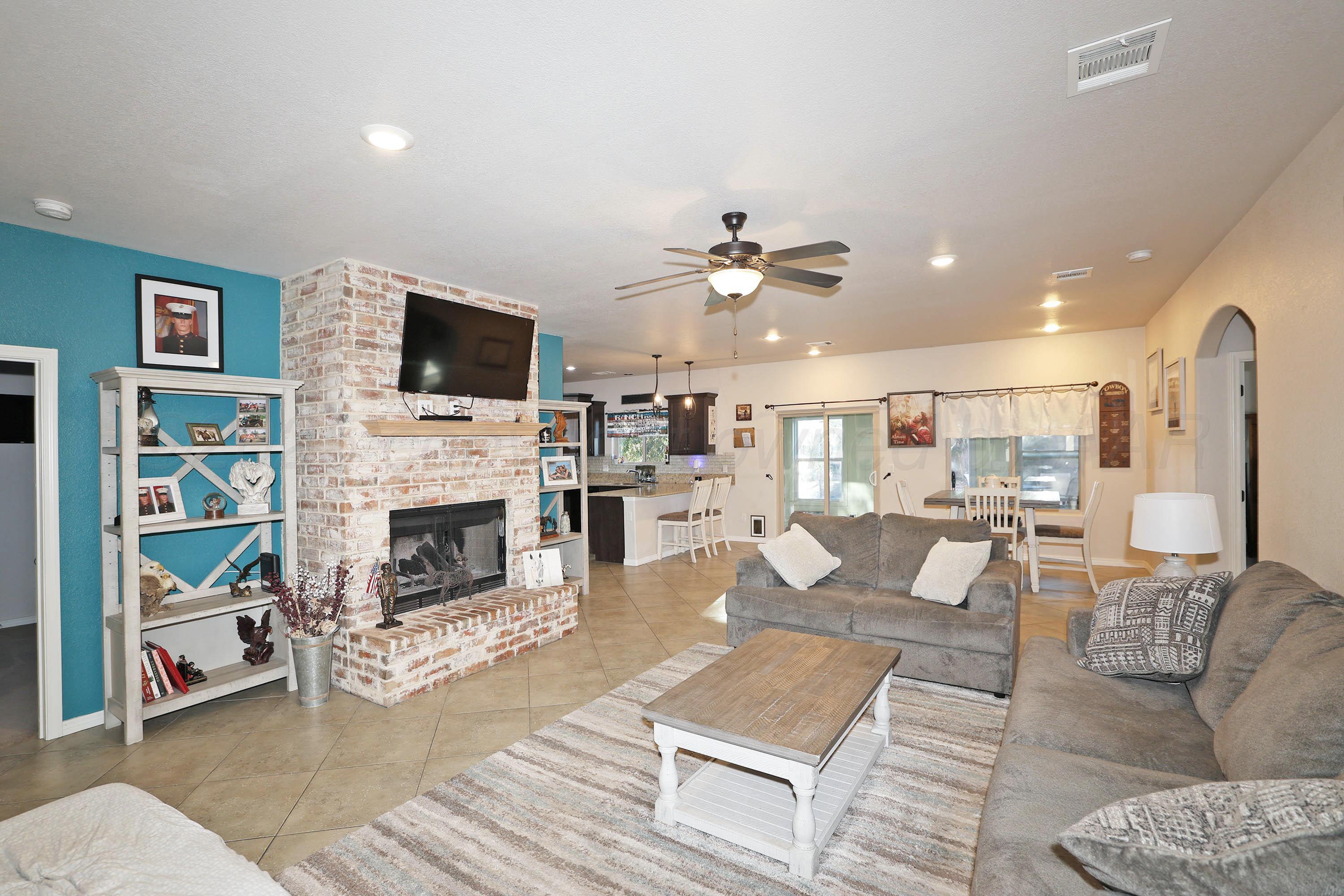 1003 Cabernet Way Amarillo, TX 79124 - Photo 8 of 36 a living room with furniture a flat screen tv and a fireplace