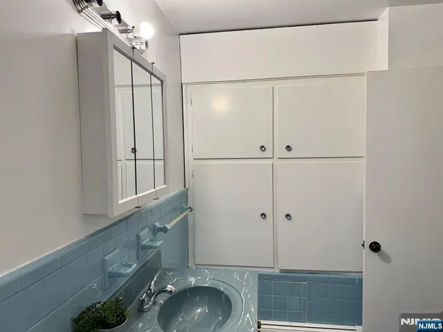 a bathroom with a granite countertop shower sink vanity and mirror