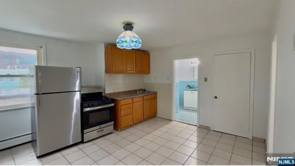 a kitchen with granite countertop a refrigerator and a stove top oven