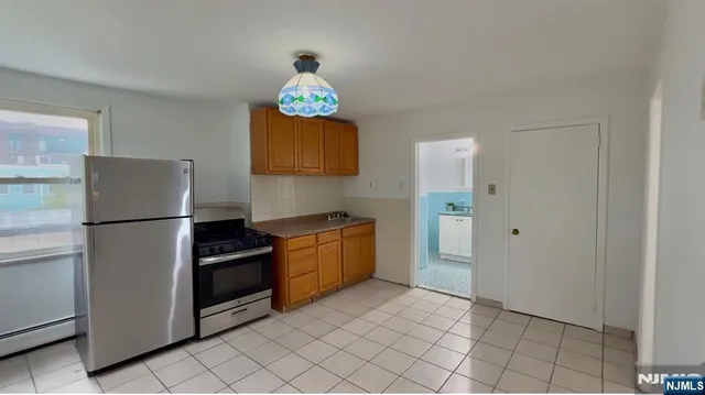 a kitchen with granite countertop a refrigerator and a stove top oven
