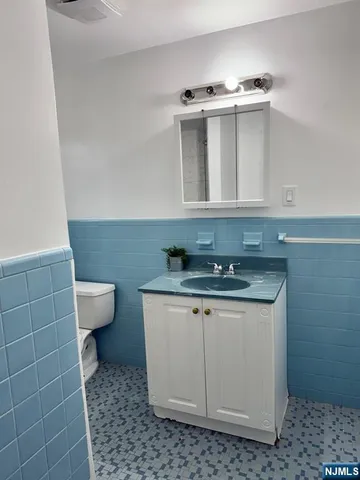 a bathroom with a sink a toilet and a mirror