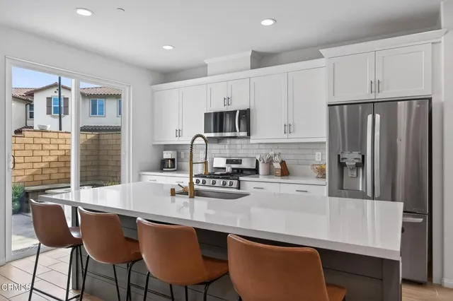 a kitchen with stainless steel appliances granite countertop a sink and a stove