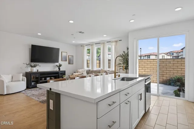 a kitchen with stainless steel appliances granite countertop a refrigerator a stove and a sink