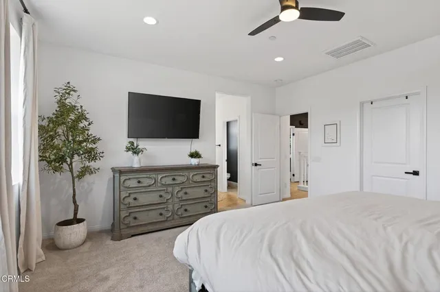 a bedroom with a bed and a flat tv screen on the dresser
