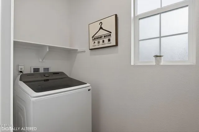 a living room with stainless steel appliances kitchen island granite countertop furniture and a large window