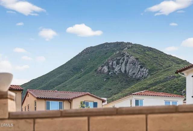 a view of a white building with a swimming pool and outdoor seating