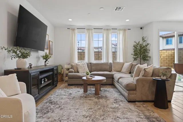 a living room with furniture a rug and kitchen view