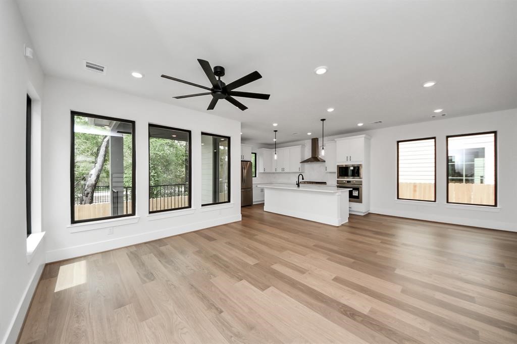 405 Forest Reserve Place Houston, TX 77079 - Photo 6 of 38 Photo of the living room with natural light flowing into the kitchen area