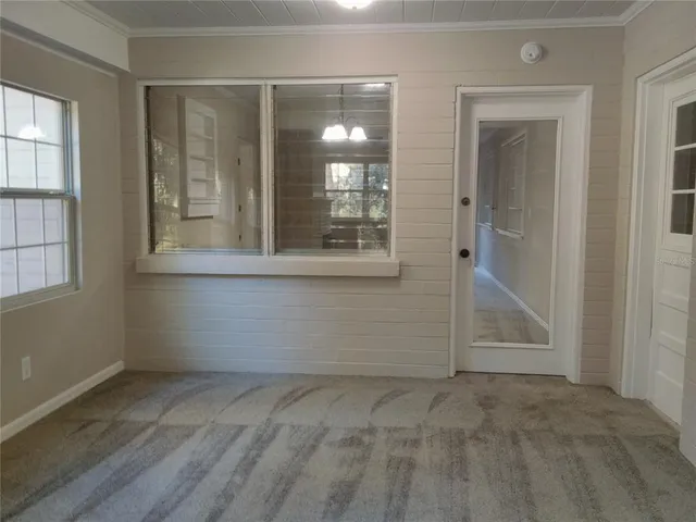 an empty room with windows and entrance