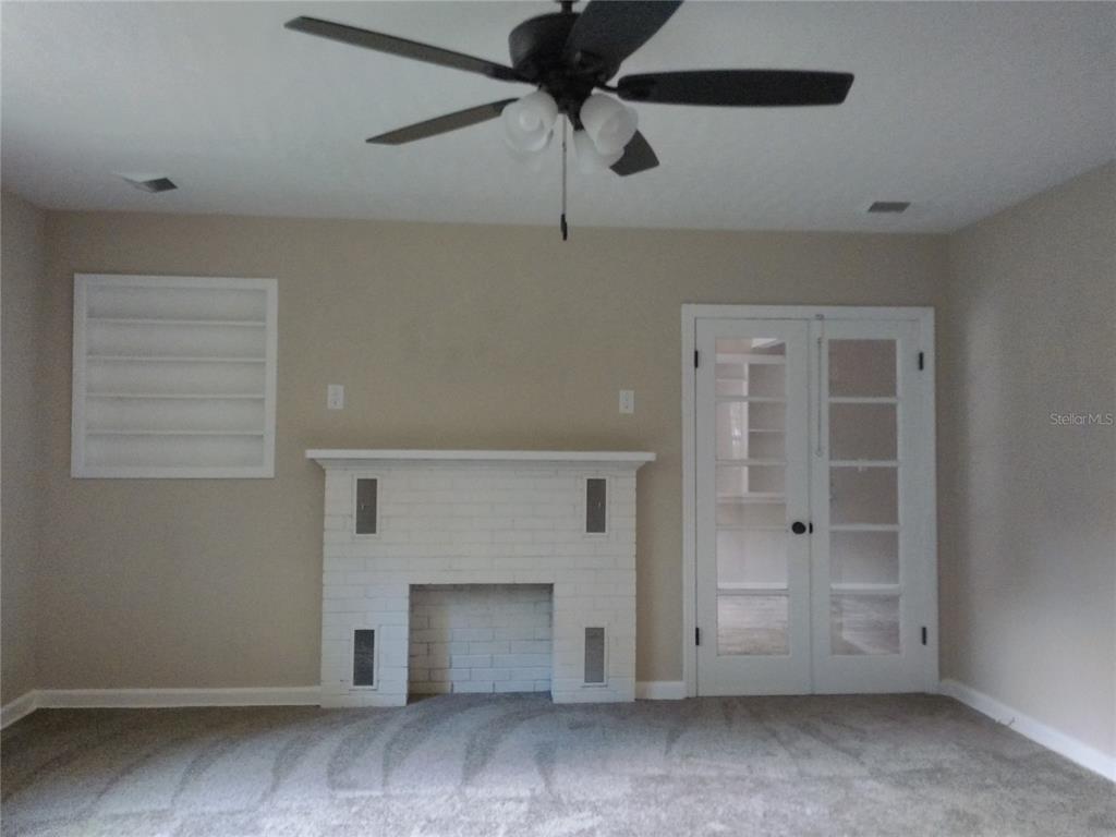 487 Rylane Street De Leon Springs, FL 32130 - Photo 16 of 40 an empty room with a fireplace