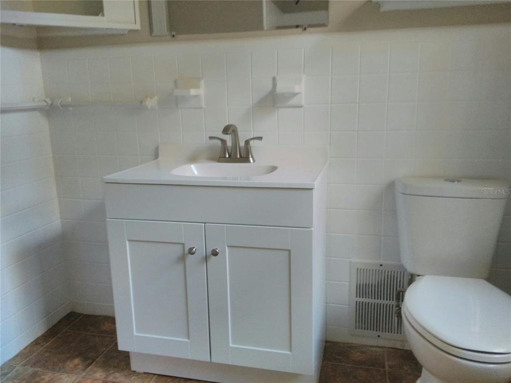 487 Rylane Street De Leon Springs, FL 32130 - Photo 23 of 40 a bathroom with a toilet a sink and mirror