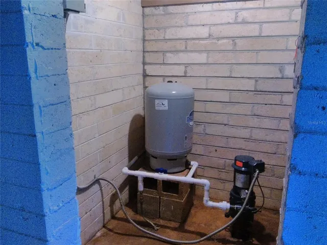a view of an empty room with windows and chandelier fan