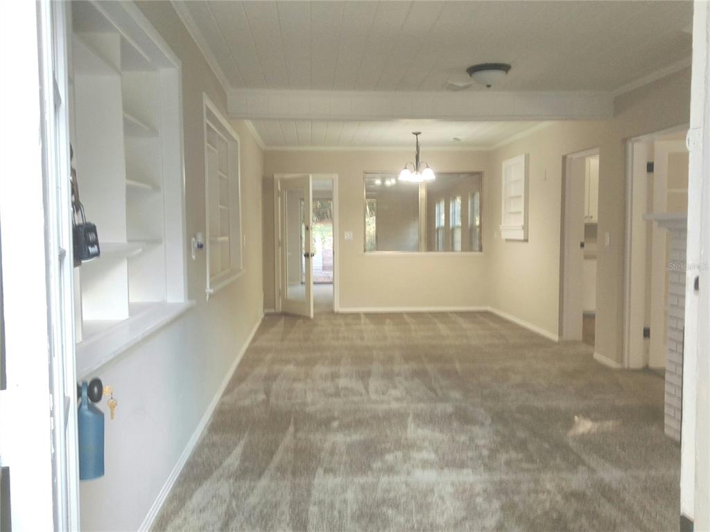 487 Rylane Street De Leon Springs, FL 32130 - Photo 6 of 40 a view of a hallway with paintings on the wall