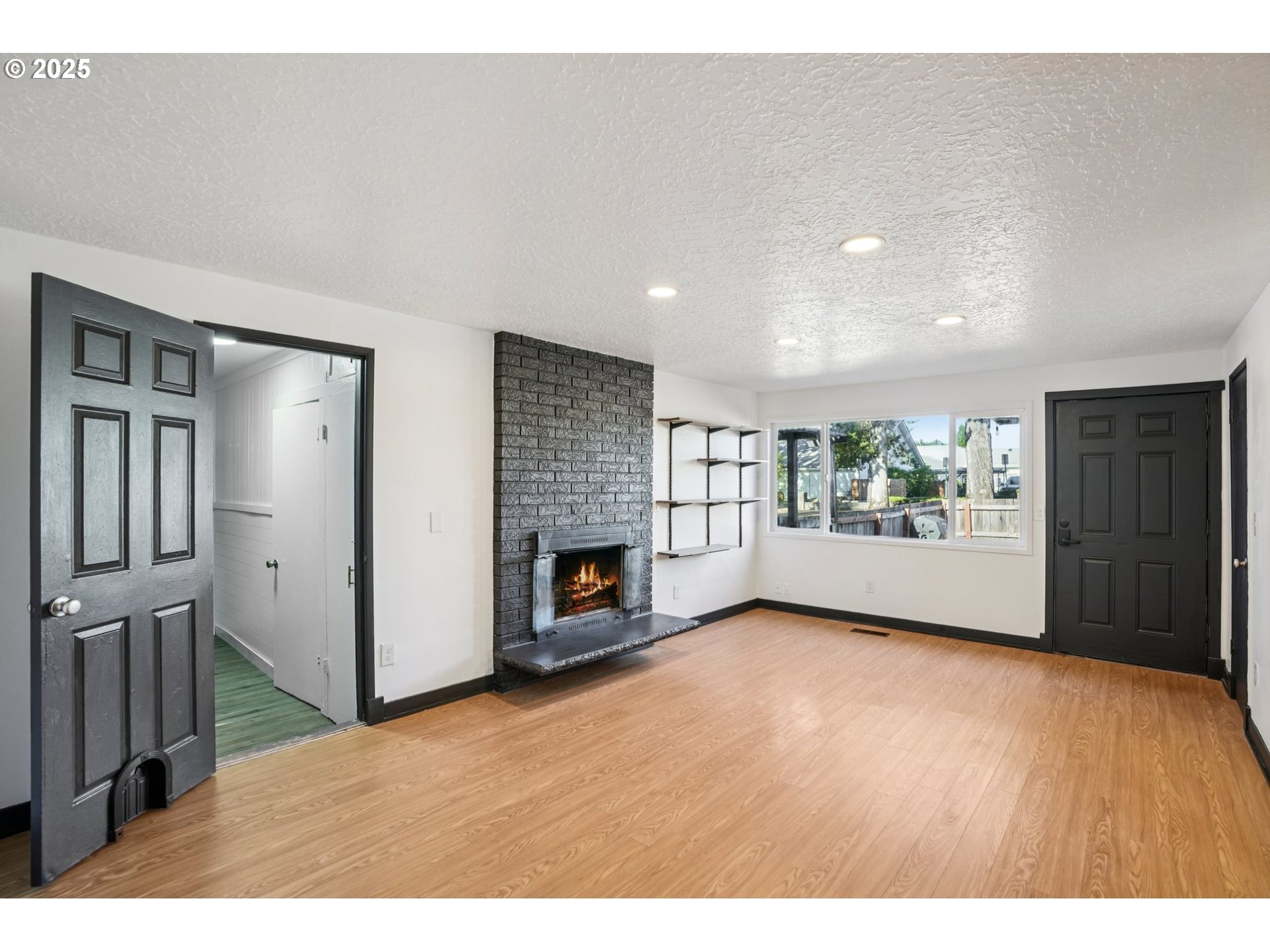 1019 Linn Avenue Oregon City, OR 97045 - Photo 6 of 27 a view of an empty room with a fireplace and a window