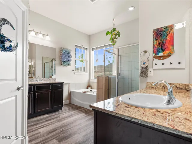 a bathroom with a granite countertop sink a mirror a vanity and shower