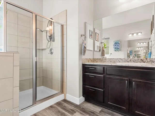 a bathroom with a granite countertop shower sink and mirror