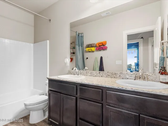 a bathroom with a granite countertop sink mirror vanity and toilet