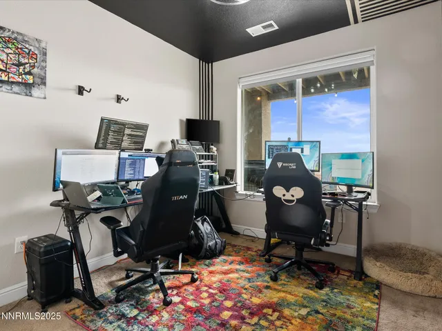 a view of a workspace with furniture and a window