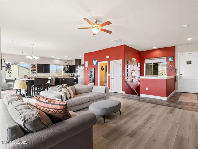 a living room with furniture kitchen view and a wooden floor