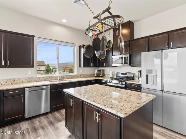 a kitchen with stainless steel appliances granite countertop a sink a stove and a refrigerator