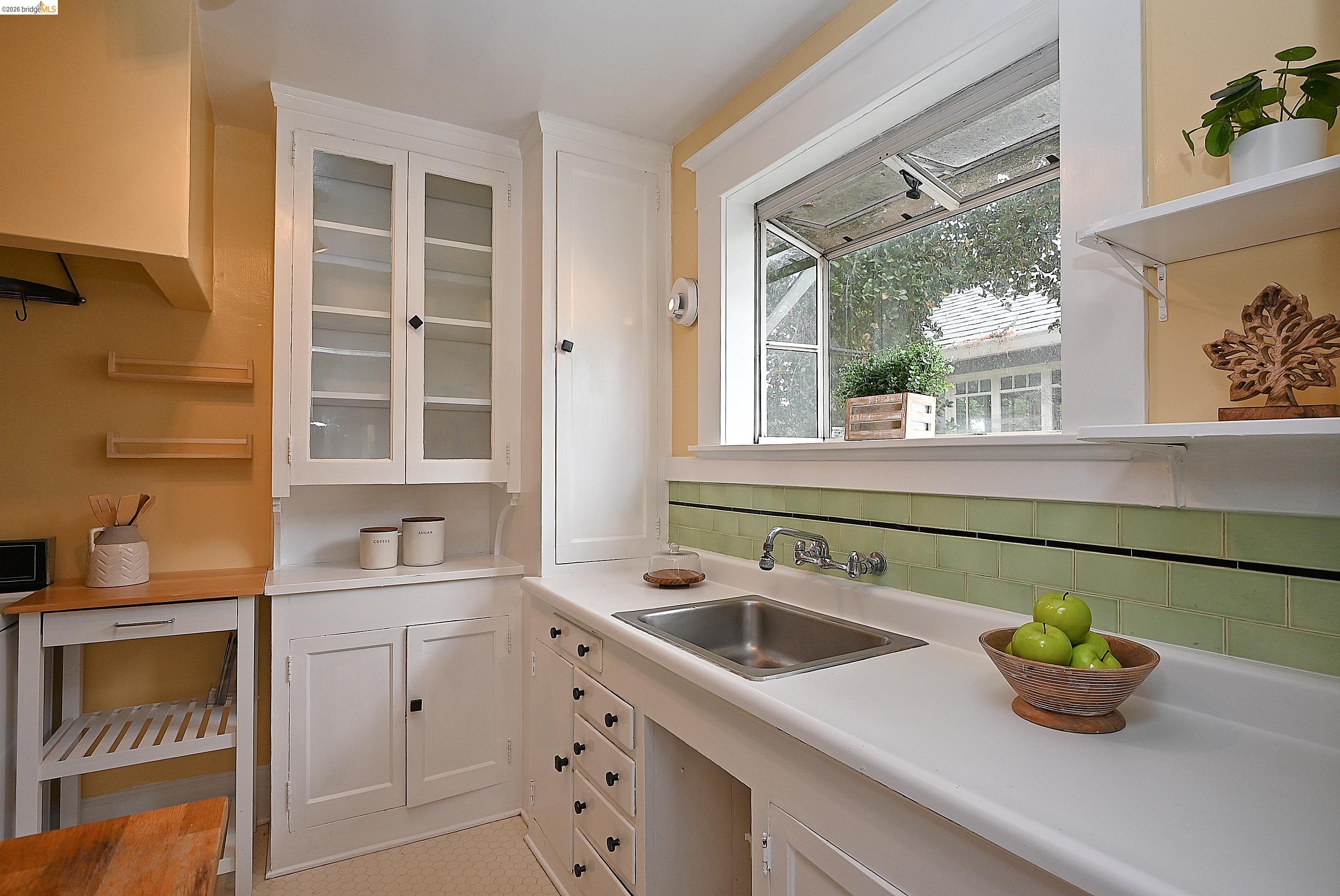 1301 Bonita Avenue, Unit 3 Berkeley, CA 94709 - Photo 30 of 48 Kitchen featuring a stainless steel sink with a dual-handle faucet, white countertops, and a green subway tile backsplash