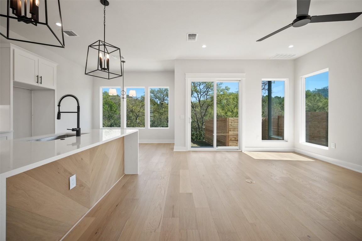 a view of a room with wooden floor windows and a chandelier