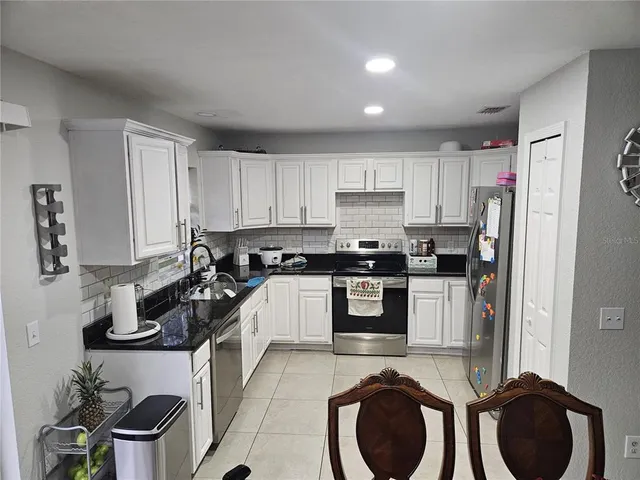a kitchen with a refrigerator sink and cabinets