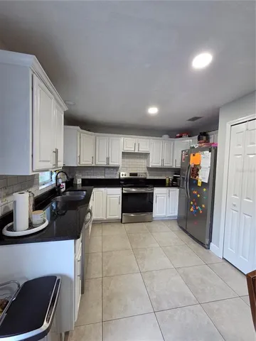 a kitchen with stainless steel appliances granite countertop a refrigerator and a sink