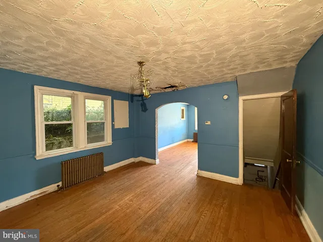 a view of a livingroom with wooden floor and a ceiling fan