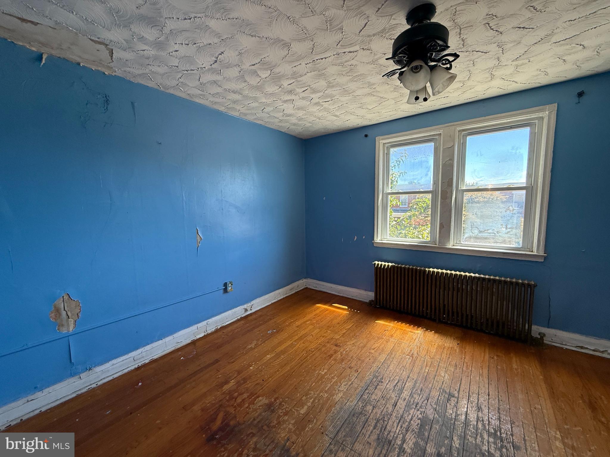 38 North Monastery Avenue Baltimore, MD 21229 - Photo 10 of 17 a view of an empty room with a window and wooden floor