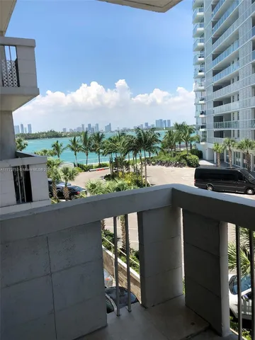 a view of a balcony with chairs and a potted plant