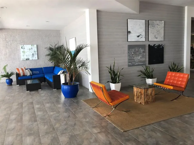 a living room with furniture flowerpot and a mirror
