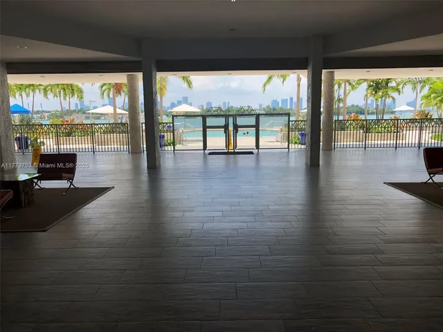 an empty room with wooden floor and floor to ceiling window