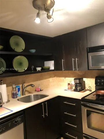 a kitchen with a sink stainless steel appliances and cabinets