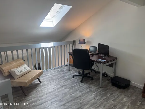 a view of a workspace with furniture and a window