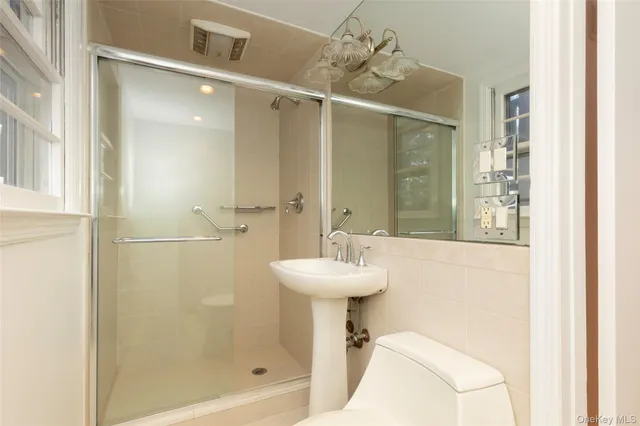 a bathroom with a sink mirror and shower