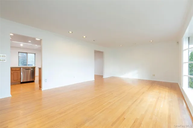 a view of a big room with wooden floor and a kitchen