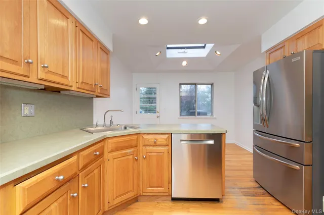 a kitchen with stainless steel appliances granite countertop a refrigerator a sink and white cabinets