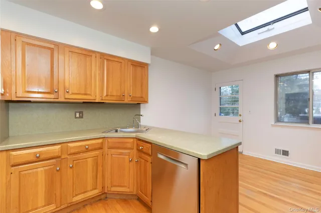 a kitchen with stainless steel appliances granite countertop a sink and dishwasher with wooden floor