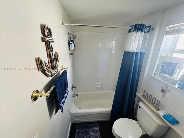 a bathroom with a shower a toilet a sink and mirror