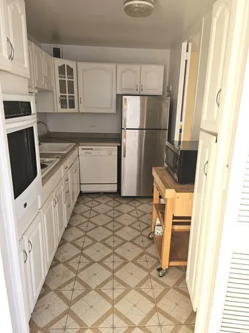 a kitchen with a refrigerator a stove top oven and a refrigerator